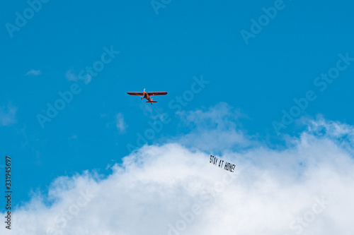 Hamburg, Germany - March 21, 2020; #StayAtHome sign pulled by an airplane flying above the city centre during the 2020 Coronavirus pandemic. 