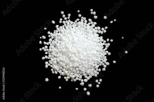 Urea fertilizer on a black background, top view. White mineral fertilizer balls - urea (carbamide). Urea nitrogen fertilizer on a black background. photo
