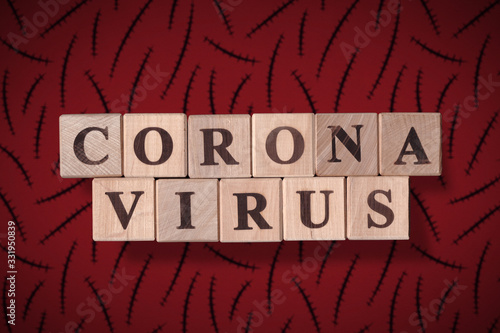 Dark brown red background with scars and with wooden cubes spelling coronavirus on it. 2019 - 2020 Novel Coronavirus (2019-nCoV) concept, for an outbreak occurs of covid-19. photo