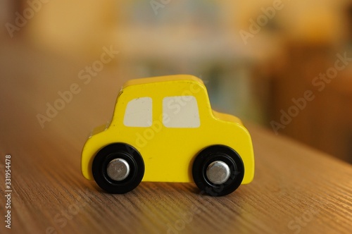 Cuadro en lienzo Closeup shot of a yellow wooden toy car on a wooden surface