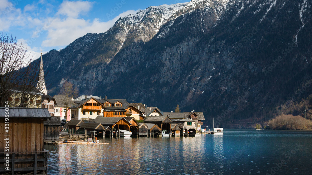 Naklejka premium Traditional wooden boat houses in Hallstatt - mountain village at Hallstaetter Lake, Salzkammergut. UNESCO world heritage site, old European architecture.