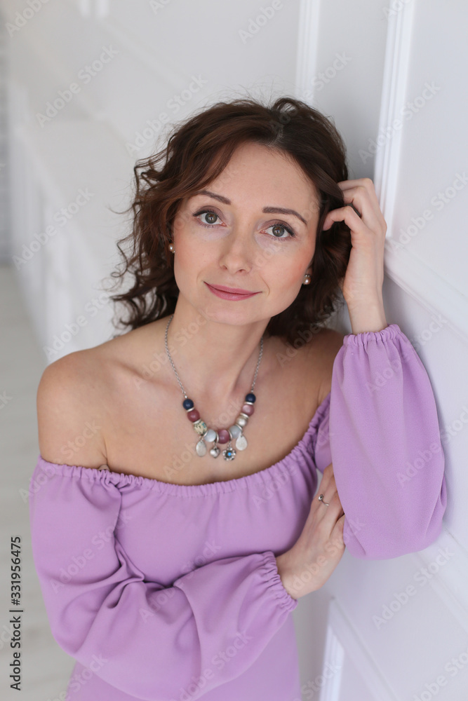 vertical close-up portrait of a cute green-eyed European woman in a dress with bare shoulders vertical close-up portrait of a cute green-eyed European woman in a dress with bare shoulders
