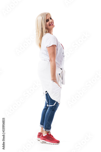 Side view of happy confident middle age blonde woman posing and looking at camera. Full body isolated on white background. 