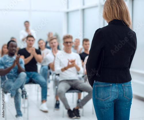 young woman standing in front of the audience in the conference room