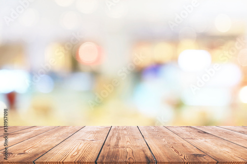 Wooden table and shopping mall with bokeh lights background