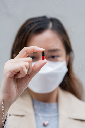 A Chinese woman hold some medicine capsules in hands. 