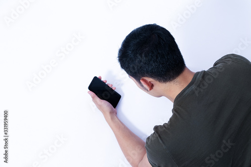 A Portrait of young asian wearing a green T-shirt take rest and using smartphone or laptop