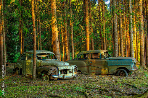 2 abandoned old rusty cars in the forest