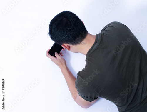 A Portrait of young asian wearing a green T-shirt take rest and using smartphone or laptop