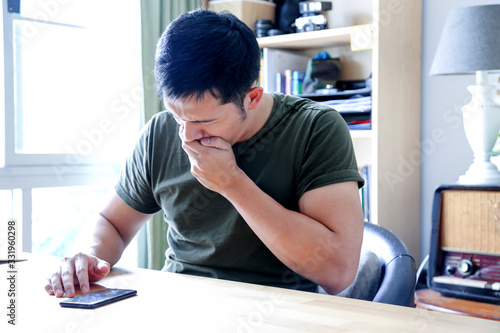 young asian wearing a green tshirt working with laptop in home office