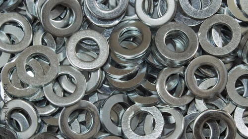 Metal washers close up slowly panning across from an overhead perspective