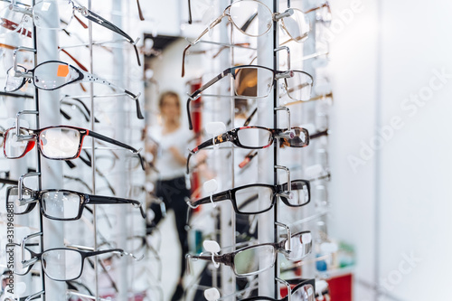 Glasses in the shop display shelves. Stand with glasses in the store of optics.