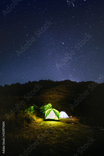 adventure travel from colourful of camping tent on the mountain with soft focus star background in summer season