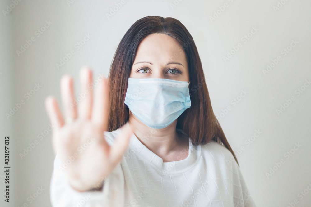 Young brown-haired woman protected with a medical mask and latex gloves, COVID-19, coronavirus, selective focus Young brown-haired woman protected with a medical mask and latex gloves, COVID-19, coronavirus, selective focus