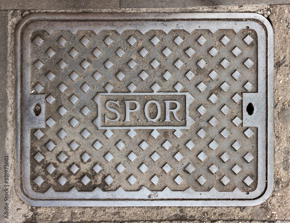 Rome, Italy - Characteristic iron manhole cover in the streets of the city of Rome, with the inscription SPQR (Senatus Populusque Romanus, Rome, Italy - Characteristic iron manhole cover in the streets of the city of Rome, with the inscription SPQR (Senatus Populusque Romanus,