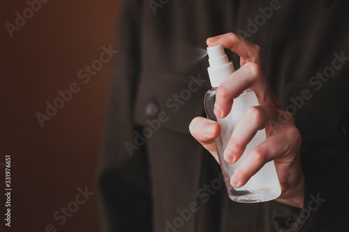 Close-up of hands applying alcohol spray against coronavirus, close up. Antiseptic spray to prevent spread of germs, bacteria, coronavirus and virus. Antiseptic and sanitizer.