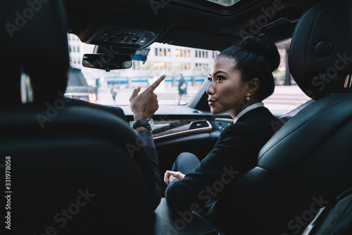 Focused ethnic businesswoman talking with colleague in car © BullRun