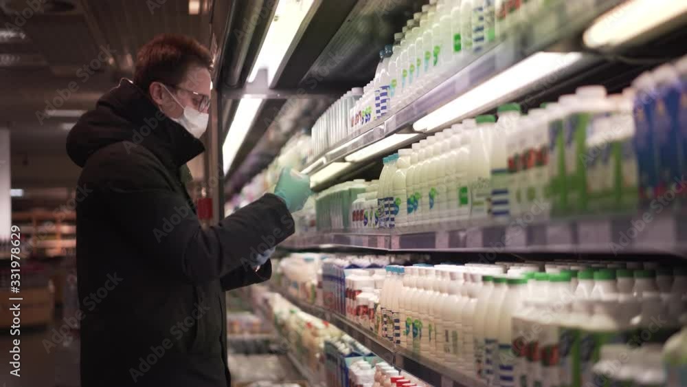 Young man looking for a milk while buying groceries during the quarantine pandemic Young man looking for a milk while buying groceries during the quarantine pandemic