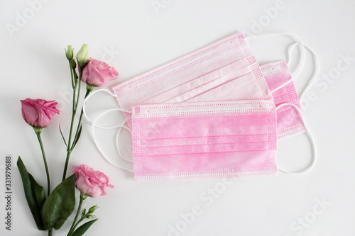 Fototapeta Naklejka Na Ścianę i Meble -  Flatlay with medical personal protective equipment for colds and flu prevention, isolated on white background. pink face masks and flowers.overhead,top view,copy space, place for text