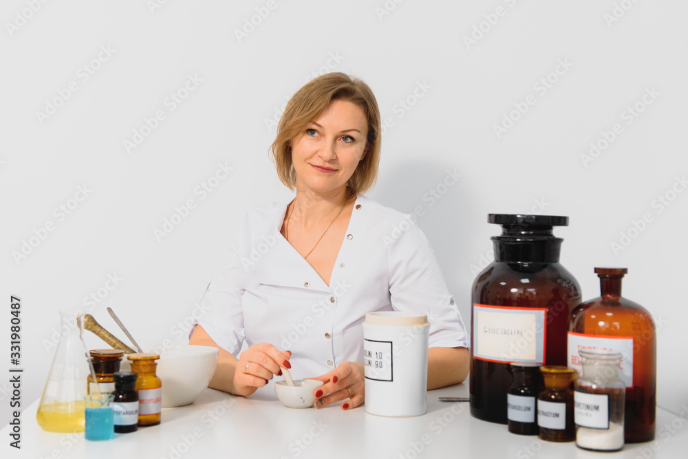 Professional pharmacist grinding a medical preparation using a mortar and pestle, pharmacy and medicine concept. Professional pharmacist grinding a medical preparation using a mortar and pestle, pharmacy and medicine concept.