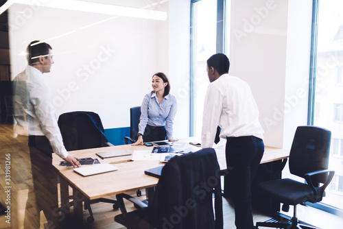 Multiracial coworkers talking in office