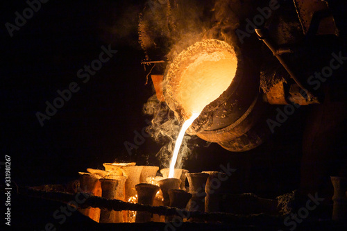 Industrial lost wax casting. The process of pouring for filling out ceramic shells with molten steel. photo