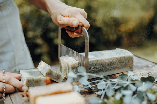 Woman is making handmade natural soaps on an old wooden table photo