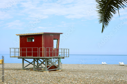 Red lifeguard hut on the empty beach © jobi_pro