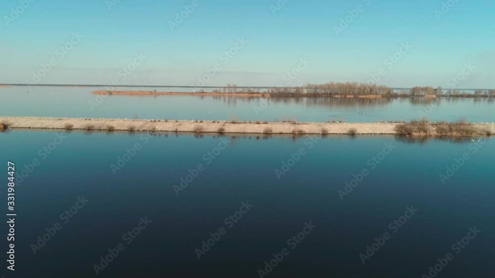 Aerial view of concrete breakwater with a flock of seagulls on calm water. Aerial view of concrete breakwater with a flock of seagulls on calm water.