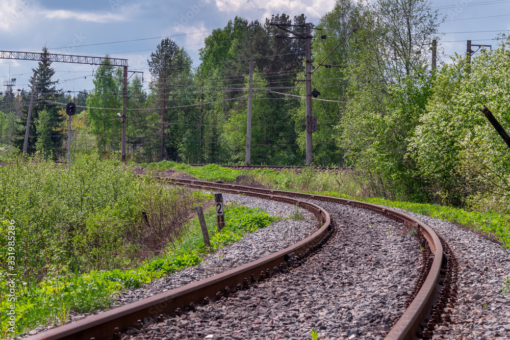 Obraz premium The railway path running through a line with a slightly blurred forground bright May day with a blurry foreground