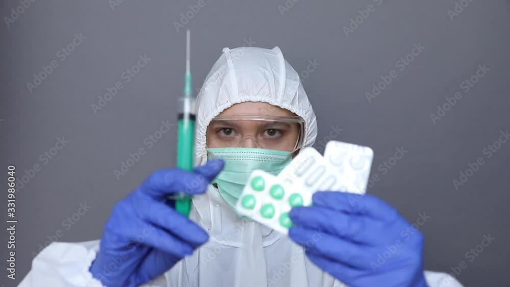 Woman in protective wear looks on pills Woman in protective wear looks on pills