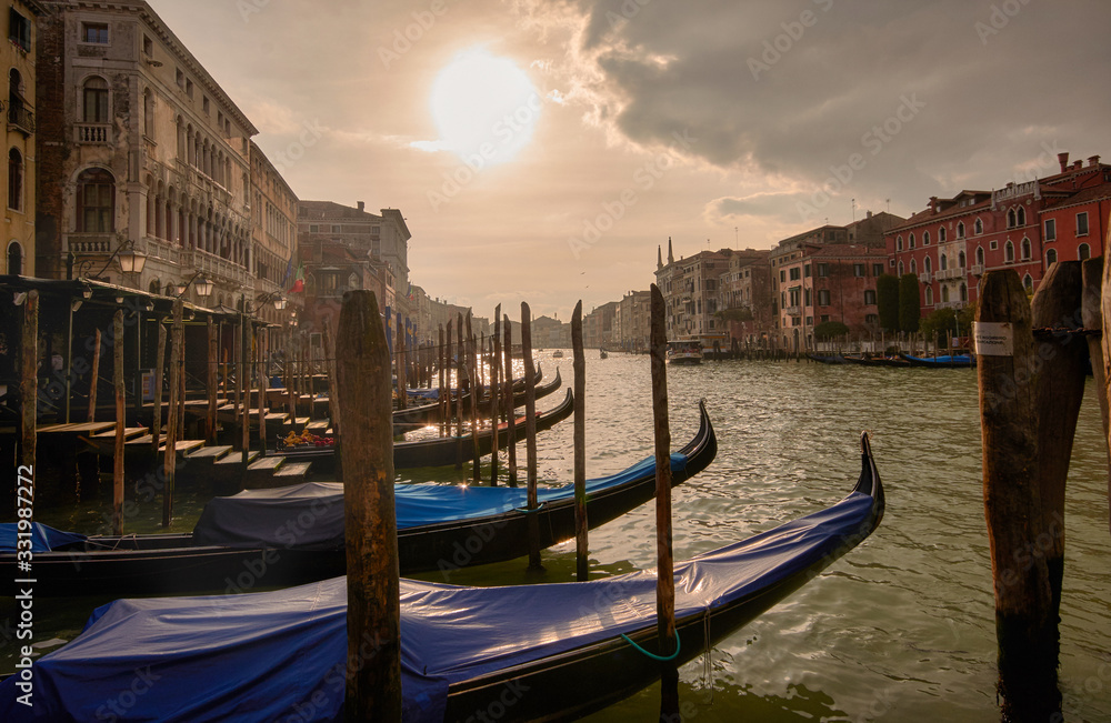 sunset on the grand canal in Venice, after a major storm. Detail of the gondolas and facades close to the great canal.