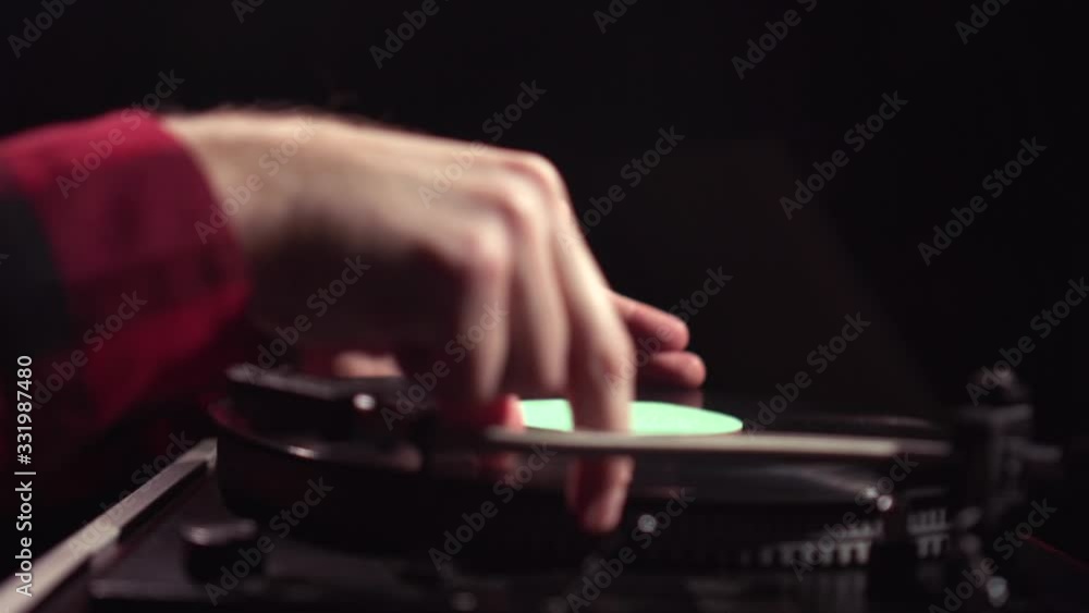 Man hands flip over vinyl record and put LP disc on turntable retro DJ 1960s player and press start button needle playing Man hands flip over vinyl record and put LP disc on turntable retro DJ 1960s player and press start button needle playing