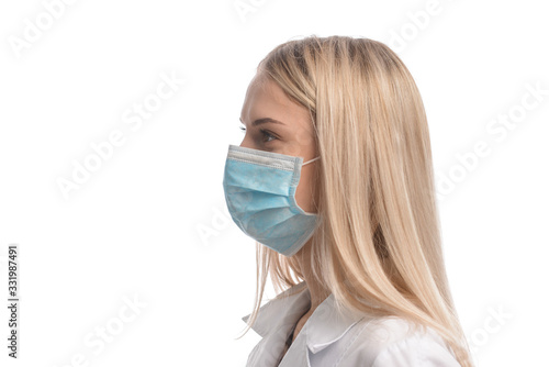 young beautiful girl with blond hair in a medical mask. On white background. Coronavirus