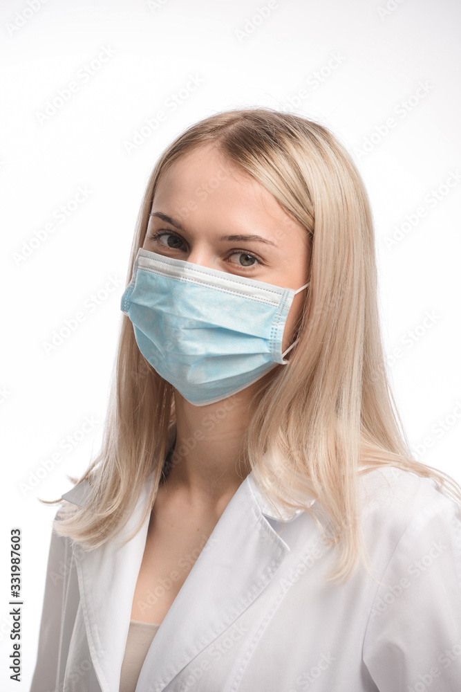 young beautiful girl with blond hair in a medical mask. On white background. Coronavirus young beautiful girl with blond hair in a medical mask. On white background. Coronavirus