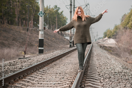 Nice modern girl walking on rails, psychology of young woman, carelessness 