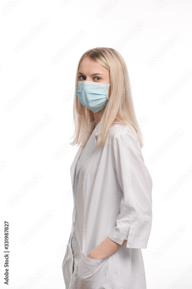 young beautiful girl with blond hair in a medical mask. On white background. Coronavirus