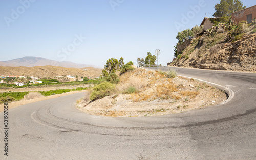 a paved road with a 360 degree curve next to Santa Fe de Mondujar town, Almeria, Andalusia, Spain photo