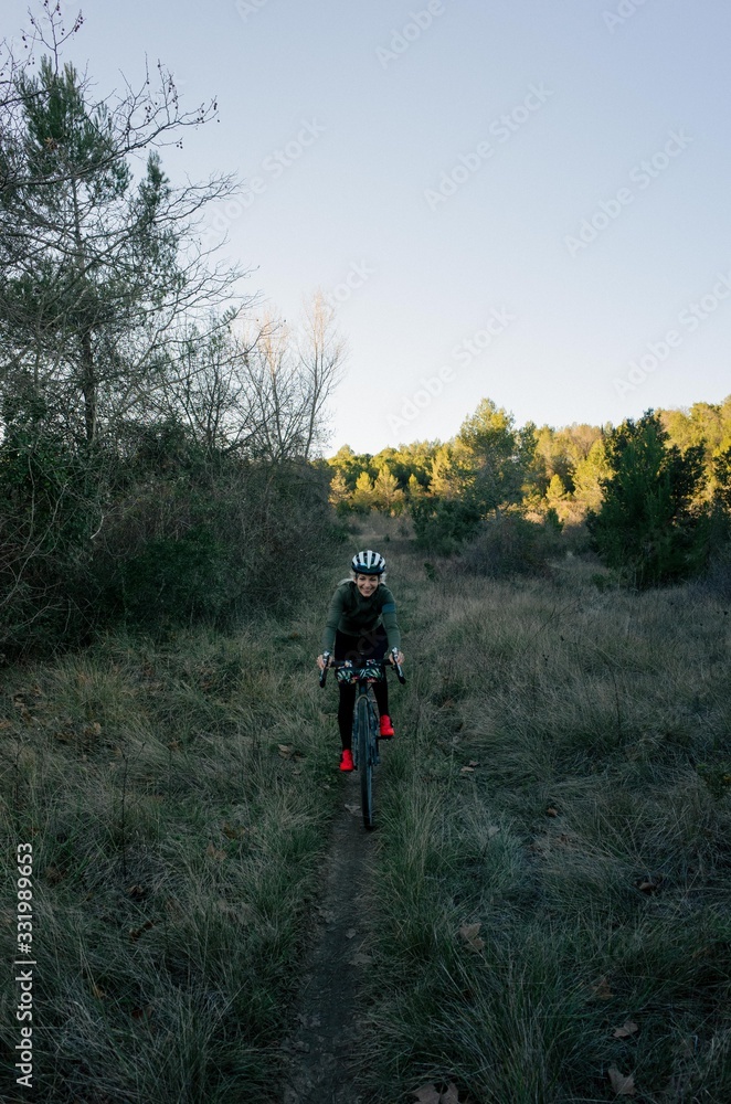 Female cyclist ride sunset in forest