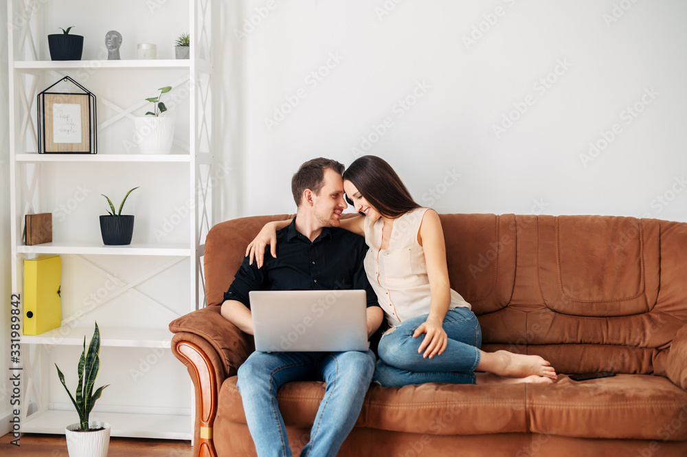 Young married couple on a sofa with a laptop