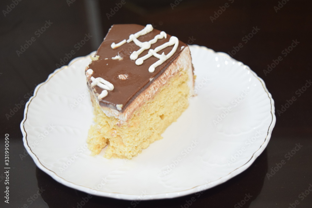 Tasty slice of three milk cake with white plate and dark background Tasty slice of three milk cake with white plate and dark background