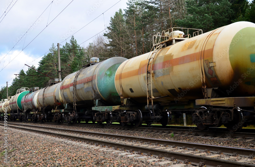Freight train with petroleum tank cars on railroad. Rail cars carry oil and ethanol. Railway logistics explosive cargo. Transportation of methanol, crude and gas.Petrochemical tank cars Freight train with petroleum tank cars on railroad. Rail cars carry oil and ethanol. Railway logistics explosive cargo. Transportation of methanol, crude and gas.Petrochemical tank cars