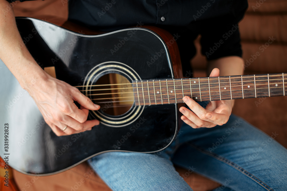 Fototapeta premium Close-up of an acoustic guitar in hands