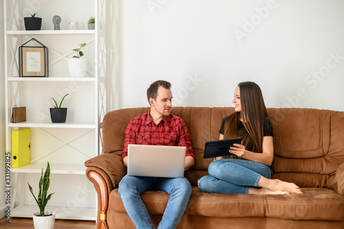 Young married couple on a sofa with gadgets