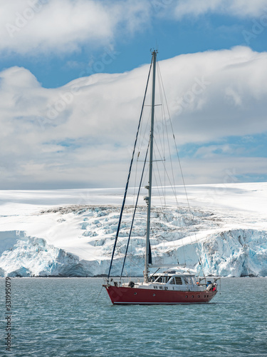 red yacht and glacier around harbour in Antarctica
