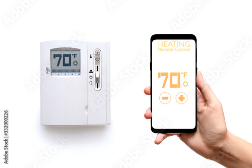 Human hand holding smart phone with smart home heating control system with thermostat regulator of temperature screen isolated on white background. New technology the running of home