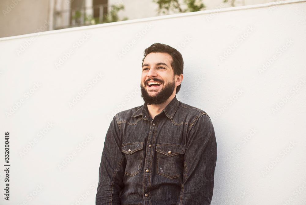 Bearded man laughs in outdoors patio Bearded man laughs in outdoors patio