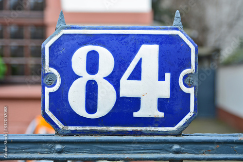 A house number plaque, showing the number eighty four (84)