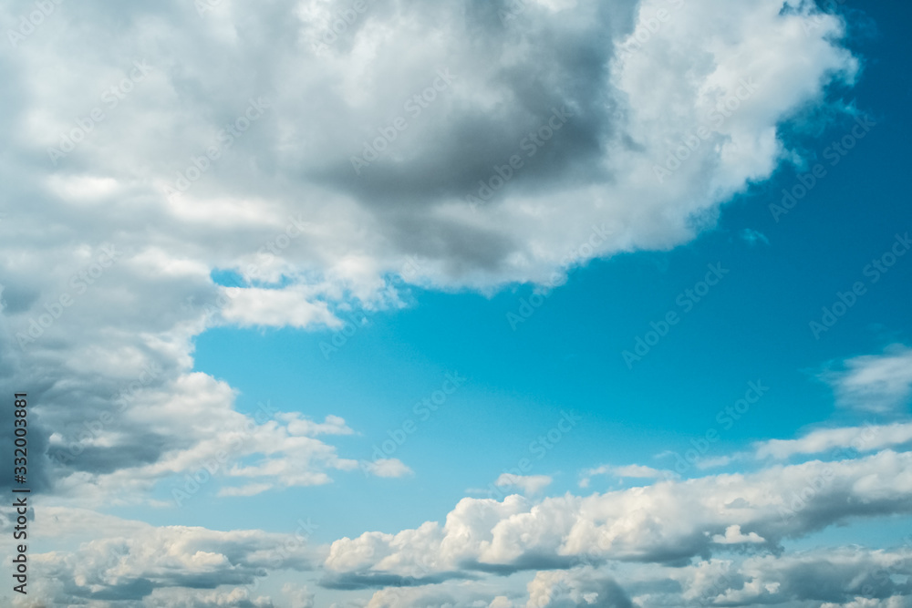 Naklejka premium Blue sky with white soft clouds. Fine warm summer weather.