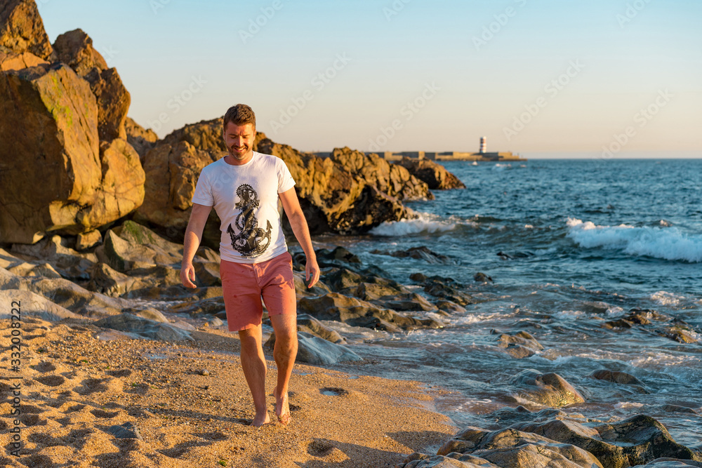Man explores the sandy beach in Matosinhos at sunset